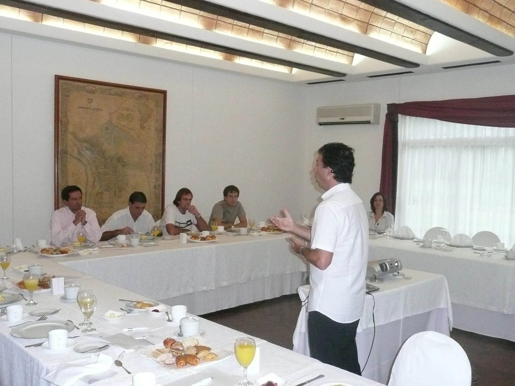 Training session in a U-shaped room with the speaker standing before the group, at an AV Business & Communication workshop