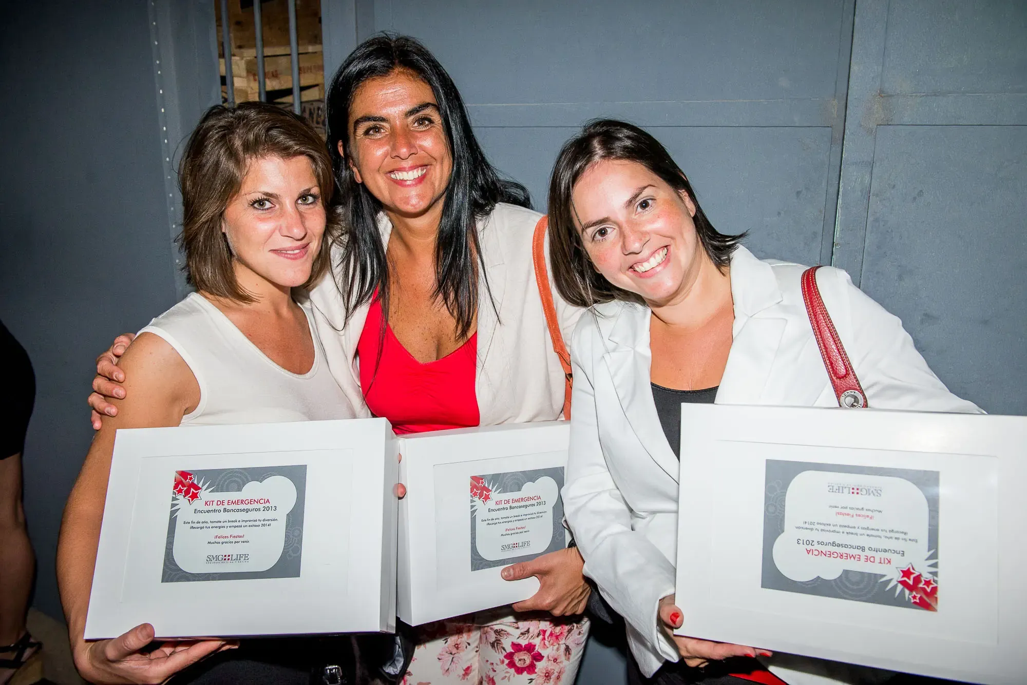 Tres participantes con sus diplomas enmarcados en una entrega de reconocimientos de AV Business & Communication