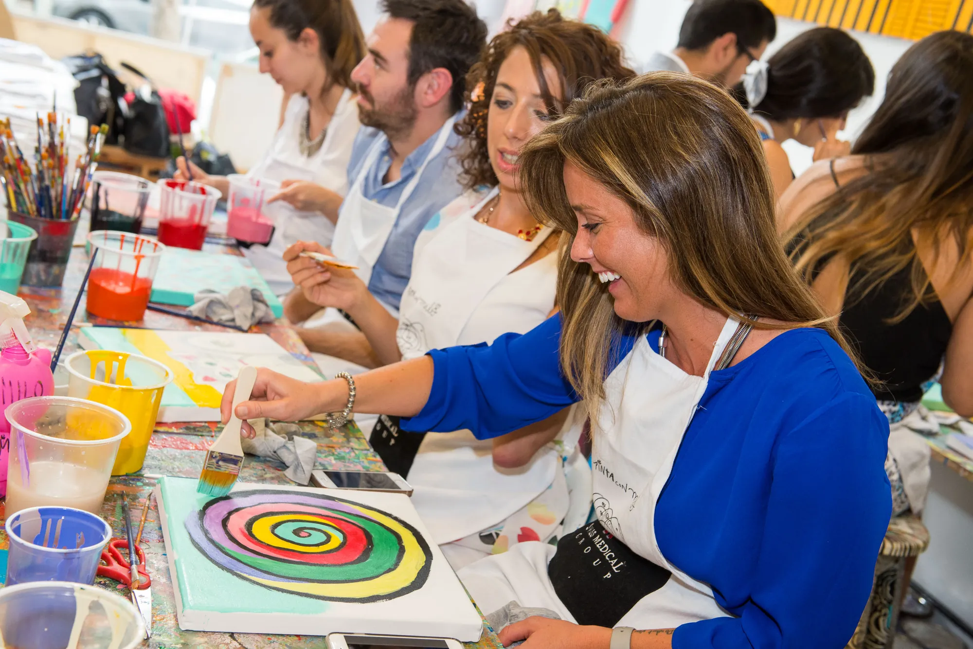 Participantes de un team building de pintura de AV Business & Communication trabajando sobre sus lienzos